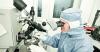Photo d'une scientifique regardant dans un microscope